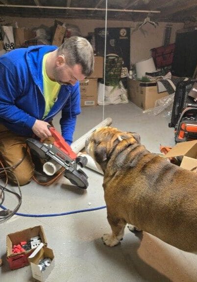 Person cutting pipe in basement with bulldog