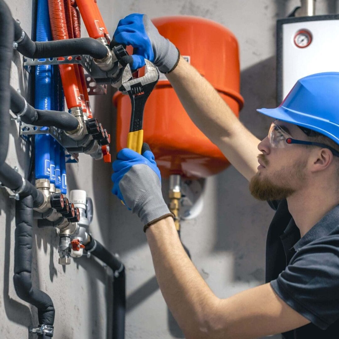 A man working on pipes in an industrial setting.